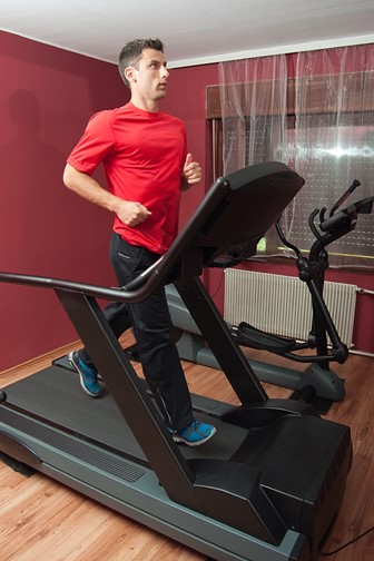 young man running on a treadmill in a home gym